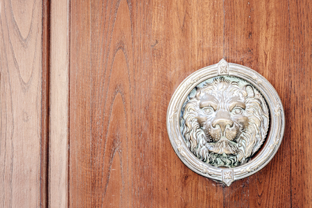 Exterior vintage door handle with circle knocker with a silver finish on a front door of an ancient building in Catania, Sicily, Italyの写真素材