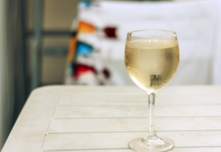 glass of white wine on wooden tableの写真素材