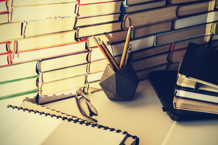 Laptop, stack of books, notebook, pencils in office background for education learning conceptの写真素材