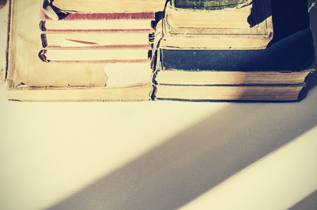 Stack of old books on white table, background for education retro concept