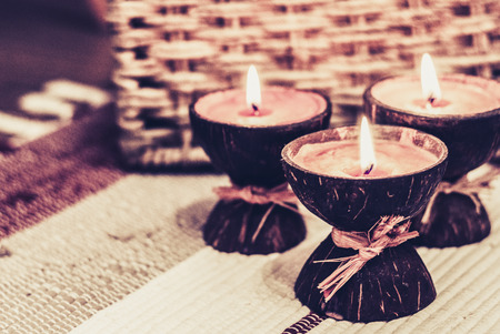 Burning spa aroma candles in coconut shell, cozy home interiorの写真素材