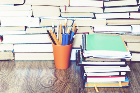 colored pencils in holder with Stack of notebooks on book education concept backgroundの写真素材