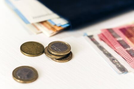 Close up money euro banknotes in blue purse and coins on white backgroundの写真素材