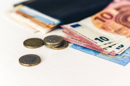 Close up money euro banknotes in blue purse and coins on white backgroundの写真素材