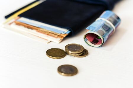 Close up money euro banknotes in blue purse and coins on white background