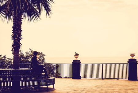 Seafront Acicastello in Acitrezza, Catania, Sicily: monument of young woman with childの写真素材