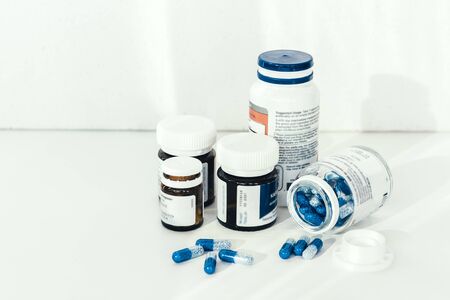 Medicine pills or capsules and bottles on white background with copy space. Drug prescription for...