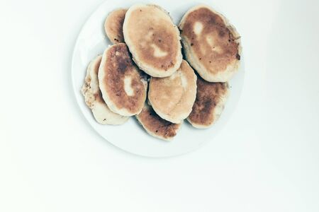 Traditional homemade fried patties or pies made of yeast dough in a rustic style on white plate