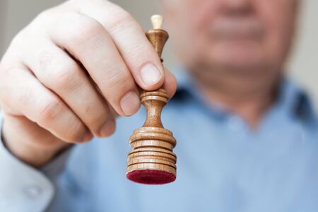 Strategy concept, hand of businessman moving wooden chess figure in play, management or leadership...