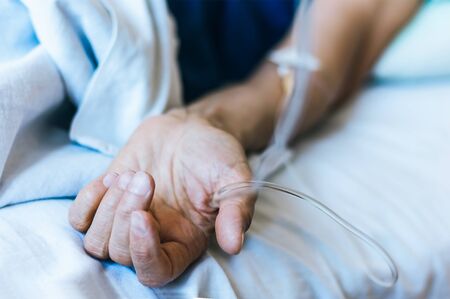 Hand of patient in serious condition is given a medicine through a dropper (healthcare background with an intravenous system)の写真素材