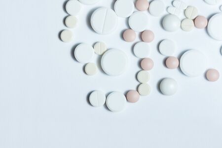 Heap of pills, pharmaceutical medicine tablets and capsules on white background. Drug prescription for treatment medication health care concept, top view with copy spaceの写真素材