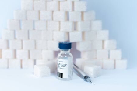 Sugar addiction, insulin resistance, unhealthy diet, sugar cubes pyramid, bottles of insulin and...