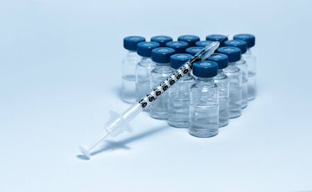 Glass medicine bottles with injection fluid with blue aluminum caps and syringe for vaccination....