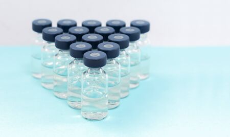 Medicine in vials, ready for vaccine injection on blue background. Cancer, painand diabetes...