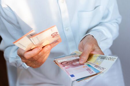 Female woman hand holds out a pack of euro close up, finance business concept