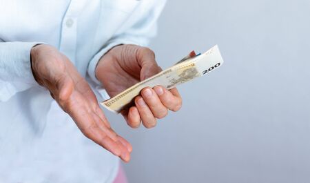Female woman hand holds out a pack of euro close up, finance business concept