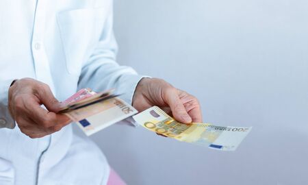 Female woman hand holds out a pack of euro close up, finance business concept