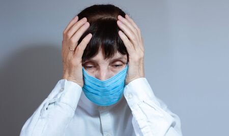 Coronavirus quarantine and Air pollution pm2.5 concept. Sick sad depressed, thoughtful old woman wearing respirator mask for protect.の写真素材