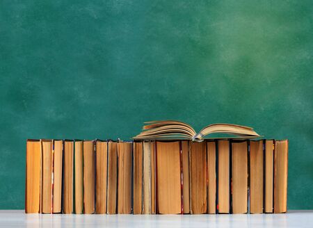 Back to school, pile of books with empty green school board background, education conceptの写真素材
