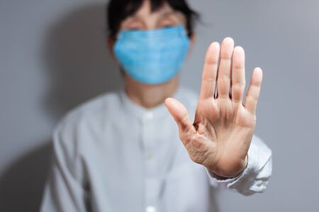 Stop coronavirus quarantine and Air pollution pm2.5 concept. Sick old woman wearing respirator mask for protect with outstretched arm. epidemic virus symptoms backgroundの写真素材