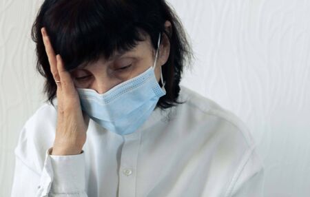 Coronavirus quarantine and Air pollution pm2.5 concept. Old sick woman wearing blue respirator mask...