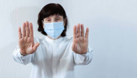 Coronavirus quarantine and Air pollution pm2.5 concept. Old sick woman wearing blue respirator mask for protect with outstretched arm.の写真素材