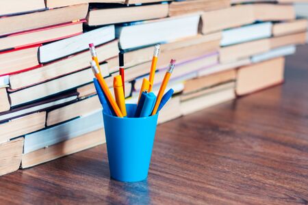 Pencils in holder and stack of books, school background for education learning conceptの写真素材
