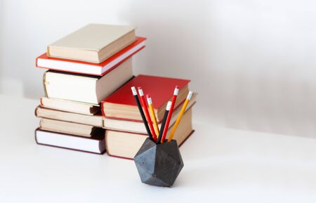Home office: textbook, notebook, stack of old books retro education back to school background,...