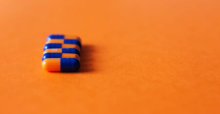 Heap of colorfull pills, tablets, capsules on yellow orange background. Drug prescription for treatment medication health care concept wth copy spaceの写真素材