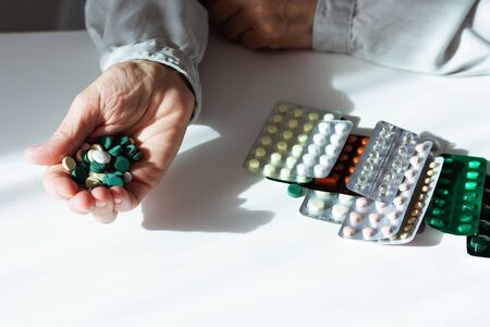 old woman hands close up take a pill from a blister of medicine, healthcare concept background, many pillsの写真素材