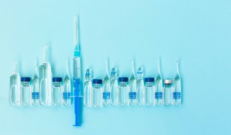 injection ampoules, syringe for vaccination on a blue background
