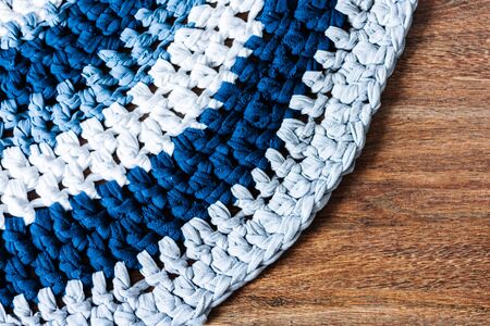 handmade round wicker rug on a wooden floor, cozy home interior decor in blue, gray and white colorsの写真素材