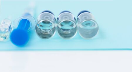 injection ampoules, syringe for vaccination on a blue background, healthcare coronavirus, cancer, painand treatment, pharmaceutical medicine conceptの写真素材