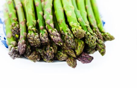 Bunch of fresh raw asparagus on white background, vegetarian concept. Green grass sparrowgrass sticks, food for veggieの写真素材