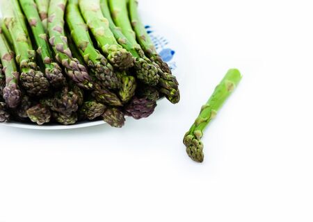 Bunch of fresh raw asparagus on white background, vegetarian concept. Green grass sparrowgrass sticks, food for veggieの写真素材