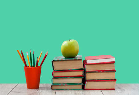Books textbook in colorful covers on a green background. Back to school distance home...