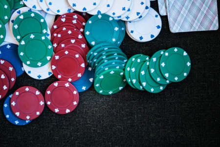 Casino poker chips stack with playing cards, dice and money on green felt backgroundの写真素材