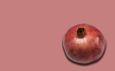 ripe red pomegranate fruit on pink background with copy space for your text, healthy vegetarian diet top viewの写真素材