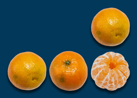Fresh whole mandarin orange background (Citrus reticulata), clean tangerine on blue background with copy space for text, healthy vegetarian diet top viewの写真素材