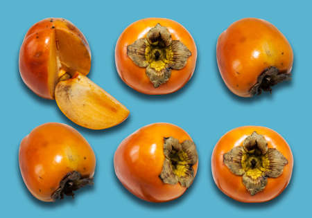 Fresh ripe whole persimmon, sharon on blue background with copy space for text, healthy vegetarian diet top viewの写真素材