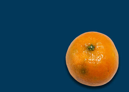 Fresh whole mandarin orange (Citrus reticulata), clean tangerine on blue background with copy space for text, healthy vegetarian diet top viewの写真素材