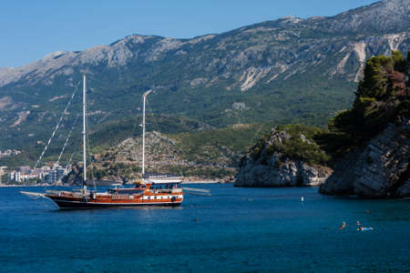 Budva, Montenegro - August 12 2021: pleasure boat near the coast with a public beach near the city of Budvaのeditorial素材