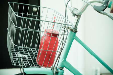 Red cocktail bottle in bike basketの写真素材