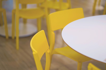 Interior of white table and yellow chair in food court shopping mall. Food center in department store.の写真素材