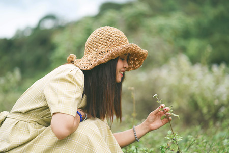 Beautiful Asian woman looking at flowers on the ground.
