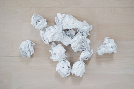 Crumpled paper on a wooden floor. Close up.