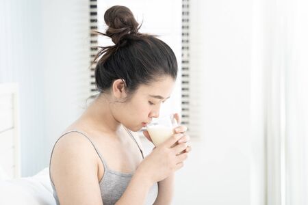 Asian pregnant woman holding a glass of milk.の写真素材