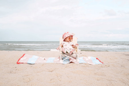 Asian baby girl sitting on beach chair and wearing sunglasses.の写真素材