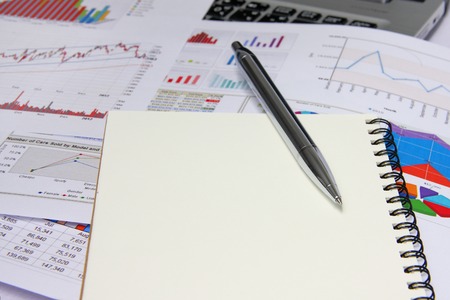 Business marketing chart with notebook and silver pen on table.の写真素材