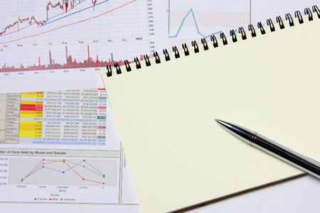 Business marketing chart with notebook and silver pen on table.の写真素材